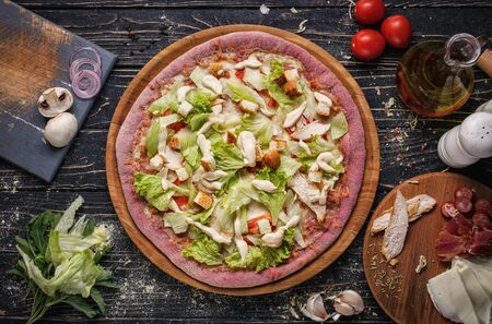 Top view of pizza with chicken meat, tomatoes, bread and lettuce on wooden plates. Italy food. Ingredient composition for pizza. Flat lay.の写真素材