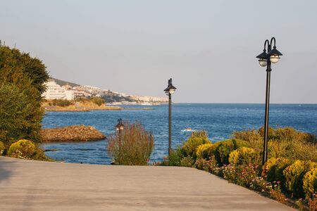 Embankment by the sea. Beautiful bushes and the sea. Tourist city in the backgroundの写真素材