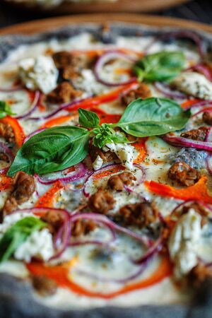A basil leaf on delicious Italian pizza is close up. Fresh baked pizza. Pizza menu.の写真素材