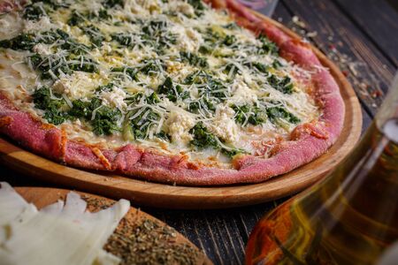 Close view of tasty appetizing classic italian traditional pizza. Food ingredients and spices for cooking pizza. Concept for a tasty and hearty meal. Rustic wooden backgroundの写真素材