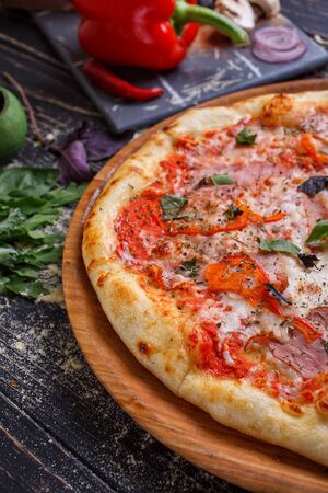 Tasty appetizing classic italian traditional pizza. Concept for a tasty and hearty meal. Rustic wooden background. Pizza menu.の写真素材