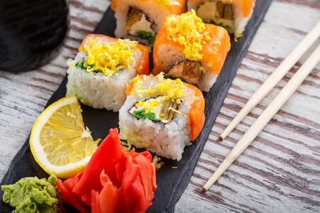 Eating Sushi with chopsticks. Sushi roll japanese food in restaurant. California Sushi roll set with salmon.の写真素材