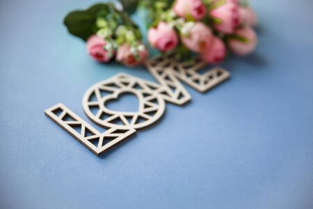 Wooden love inscription. Love background. Love and flowers on a blue backgroundの写真素材