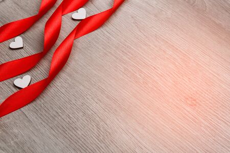 Red ribbon in the form of a spiral and decorative heart.. Mother's day. Women's day. Valentine's day, Birthday greeting concept background. top view, flat lay, mockupの写真素材