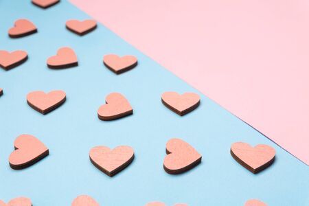 Flat lay love background. Pink and blue background. Pink wooden hearts on a blue background. Love...