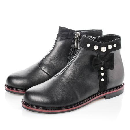 Black leather boots for girls with bow and pearls on a white background. Photo for shoes advertisement. Side viewの写真素材