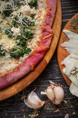 Close view of tasty appetizing classic italian traditional pizza. Food ingredients and spices for cooking pizza. Concept for a tasty and hearty meal. Rustic wooden backgroundの写真素材
