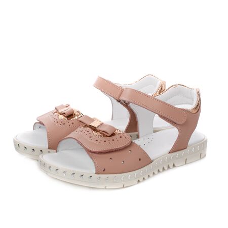 Beige sandals with a bow for girls on a white background. Photo for shoes advertisement. Side viewの写真素材