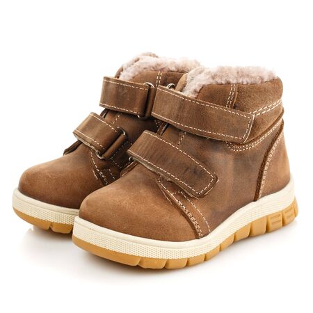 Children's brown winter boots with fur on a white background. Photo for shoes advertisement. Side viewの写真素材
