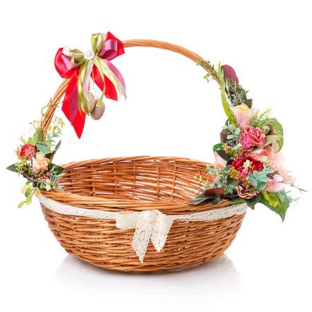 Round wicker easter basket with beautiful ribbon bow. Decor with flowers, quail eggs and ribbons on white background. Minimal decorの写真素材