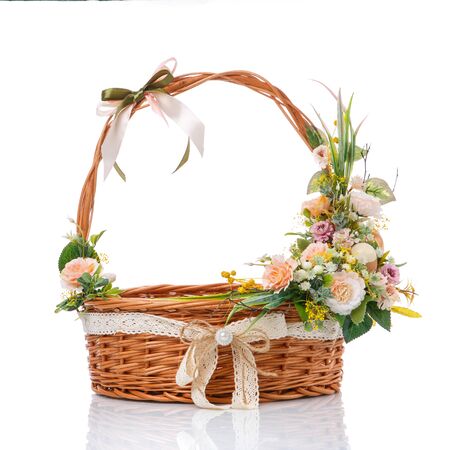 Brown wicker basket made of natural vines with a very beautiful Easter flower decor. Isolatedの写真素材