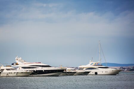 Luxury white boats on water with reflections standing on pear in sea portの写真素材