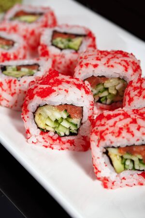 Salmon and caviar rolls are served on a white plate. Fresh Japanese food.の写真素材