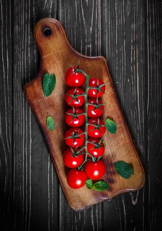 Ripe tomatoes on dark wooden background. Photo for banner and advertisingの写真素材