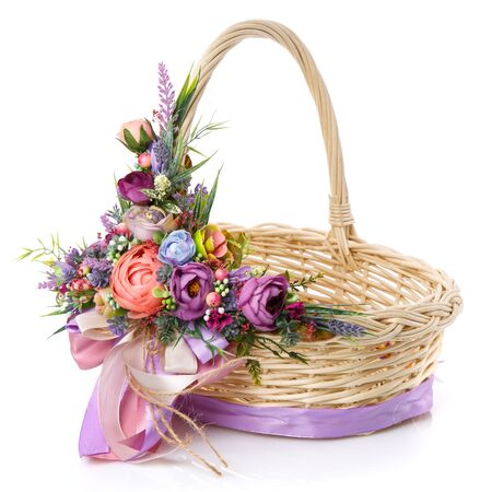 Easter basket on white background. Decorated with a large decoration of bright colored flowers, greens and ribbons. Isolated.の写真素材
