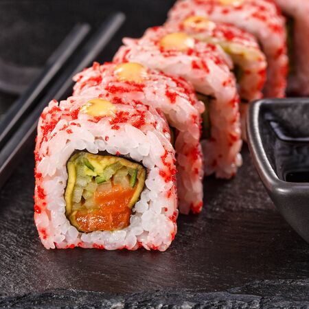 Sushi with chopsticks and soy sauce on a stone board. Japanese food. Set of sushi roll with vegetables, fish and caviar. Close up.の写真素材