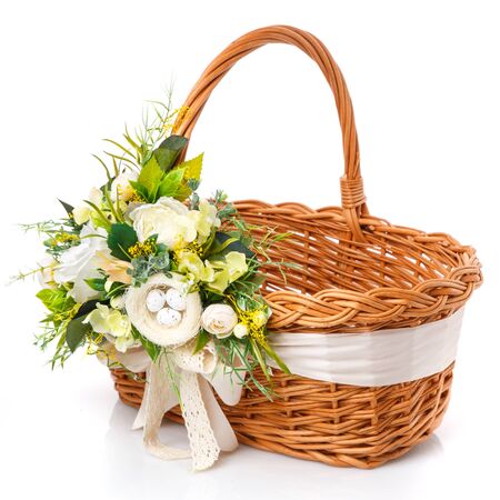 Provence Easter floral arrangement on a white wicker basket with a vine. Isolatedの写真素材