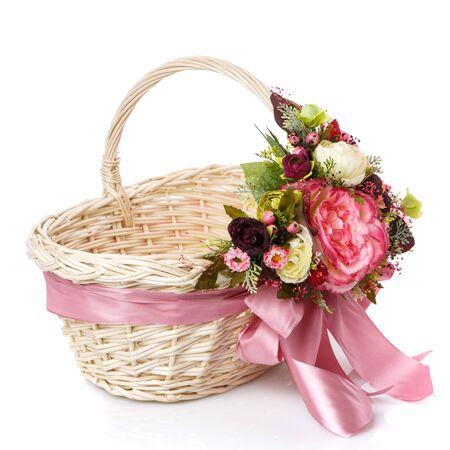 Wicker basket decorated with flowers on white background. Isolatedの写真素材