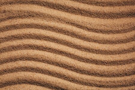 Summer sandy background or texture. Sandy waves near the sea or desert.の写真素材