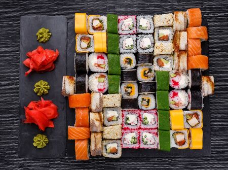 Japanese sushi food. Maki ands rolls with tuna, salmon, shrimp, crab and avocado. Top view of assorted sushi. Rainbow sushi roll, uramaki, hosomaki and nigiri.の写真素材