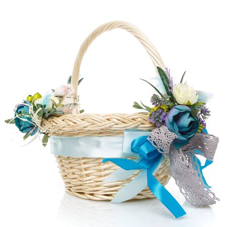 Easter basket on white background. Decorated with flowers in blue. Ribbons and lace. Side view.の写真素材
