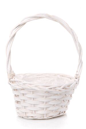 White wicker basket made of vines with high handle on a white background.の写真素材