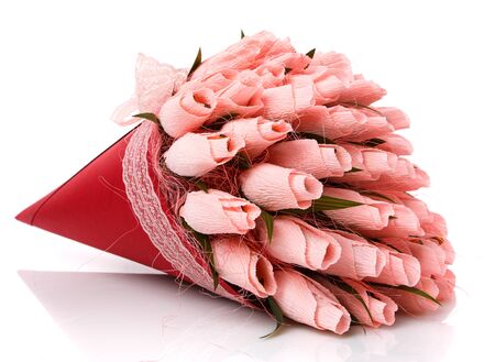 Pink tulips made of corrugated paper in a red wrap with lace on a white background. Inside the flowers are candy. Sweet bouquet. Handmade. Close up.の写真素材