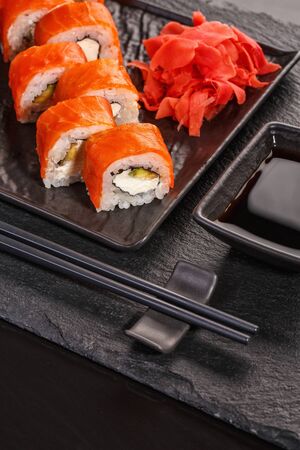 Delicious Philadelphia sushi is served in black dishes. Studio photoshoot.の写真素材