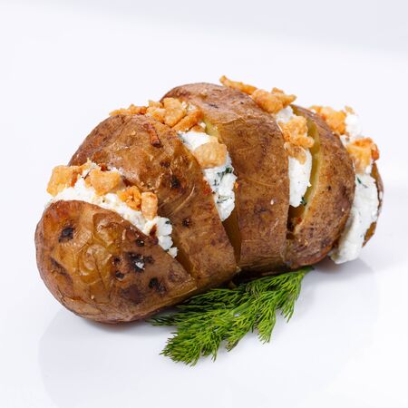 Baked potatoes with cottage cheese, fresh green, nuts and dill on a white background. Close up.の写真素材