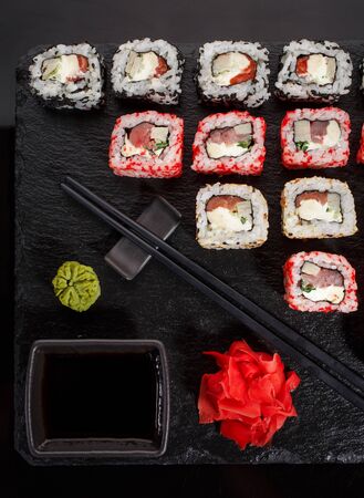 Originally put a set of sushi on a black board. With chopsticks, ginger, wasabi and soy sauce. Top view.の写真素材