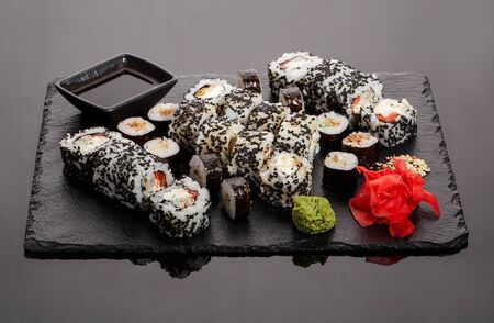 Originally put a set of sushi on a black board. With chopsticks, ginger, wasabi and soy sauce.の写真素材