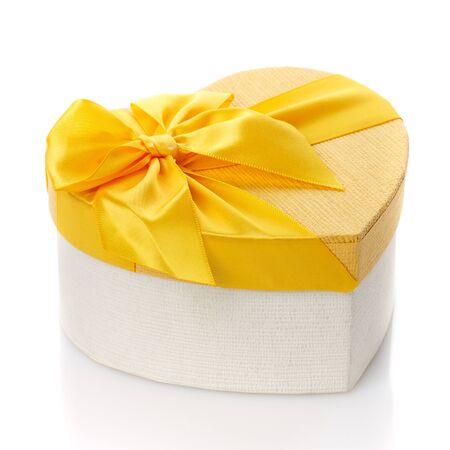 Beautiful heart shaped gift box with big yellow bow. Isolated. Side view. Concept of Valentine's day celebration.の写真素材
