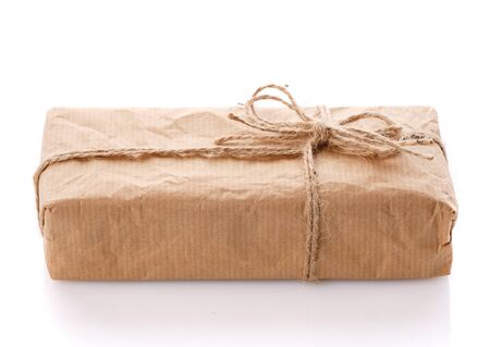 Parcel wrapped in brown kraft paper isolated on white background. Side view.の写真素材