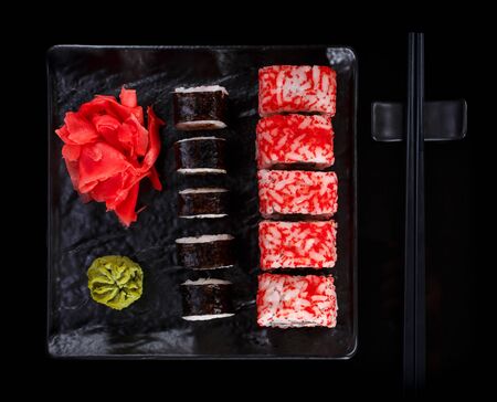 Japanese sushi on a dark stone background. Sushi set with ginger, wasabi and soy sauce. Serve with chopsticks.の写真素材