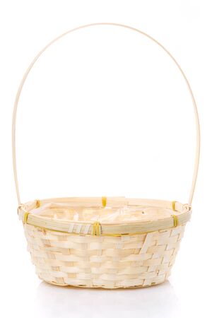 A small wicker basket made of vines with a tall handle on a white background.の写真素材