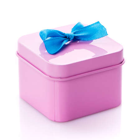 Metal pink box with blue satin bow close up isolated on white background.の写真素材
