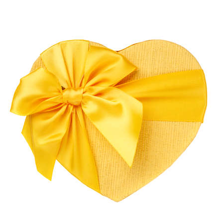 Yellow gift box in the form of heart with bow closeup on a white background. Top view. Mother's Day Gift.の写真素材
