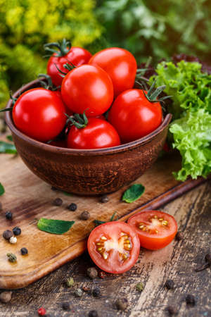 Cooking background. Fresh vegetables and peppers on wooden background. Ripe tomatoes and herbs. Food photo.の写真素材