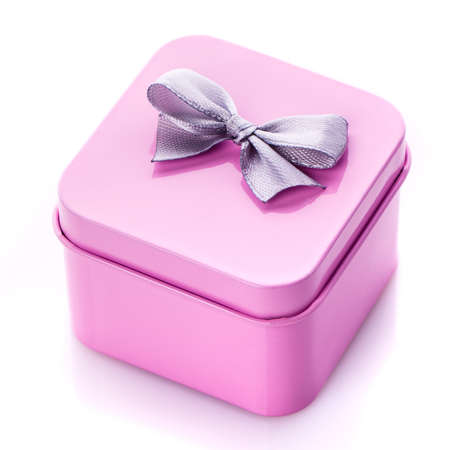 Metal square pink gift box with gray bow isolated on white background. Holiday gift.の写真素材
