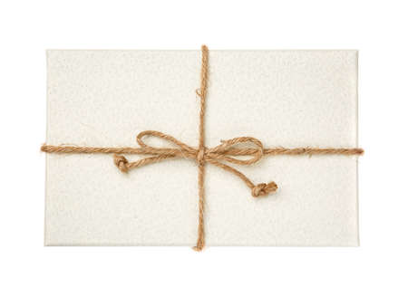 White gift box with burlap ribbon on a white background. Top view.の写真素材