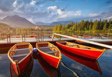The colorful boats on Strbske lake in Slovakia. High Tatras mountains national park and beautiful mountain lake in the High Tatras.の写真素材