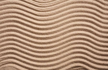 Textured wavy sand. The waves on the sand in the form of a zigzag. Sand dunes and beaches. Top view. Place for text.の写真素材