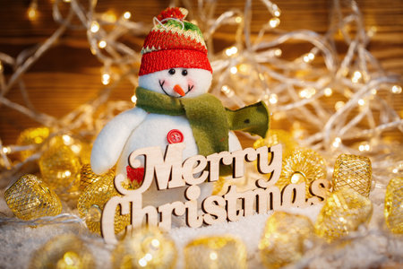 Toy snowman at Christmas garlands and text Merry Christmasの写真素材
