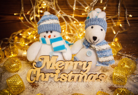 Toys on shiny garlands background. Merry Christmas and happy New Year. Wooden text.の写真素材