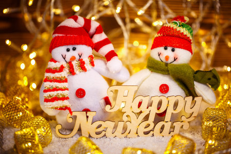 Smiling Christmas toys dressed in scarf and cap with text. Still life of Christmas toys wit garlandの写真素材