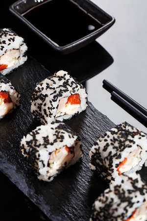 Japanese sushi with soy sauce and chopsticks on black background.の写真素材