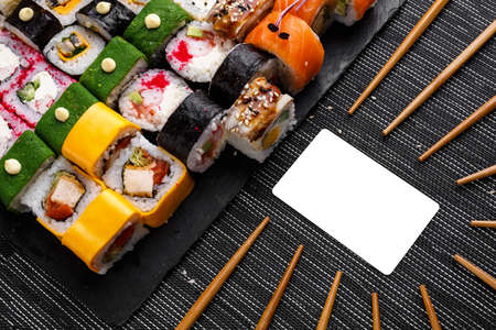 Assorted sushi set on stone background. Huge set of colored rolls with different stuffing. Salmon, tuna, eel, avocado, cucumber, Philadelphia cheese, cutlets and caviar. Top view.の写真素材