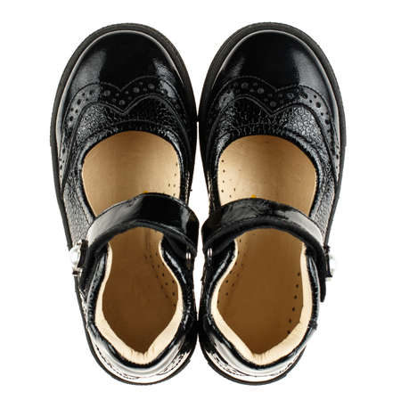 Pair of black leather baby shoes for girl on white background. Close up.の写真素材