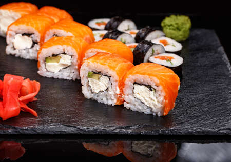 Two different types of sushi rolls on a stone board. Japanese cuisine. Selective focus.の写真素材