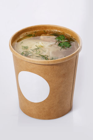 Soup in a cup of recycled paper isolated on white background. Concept of organic food packaging.の写真素材